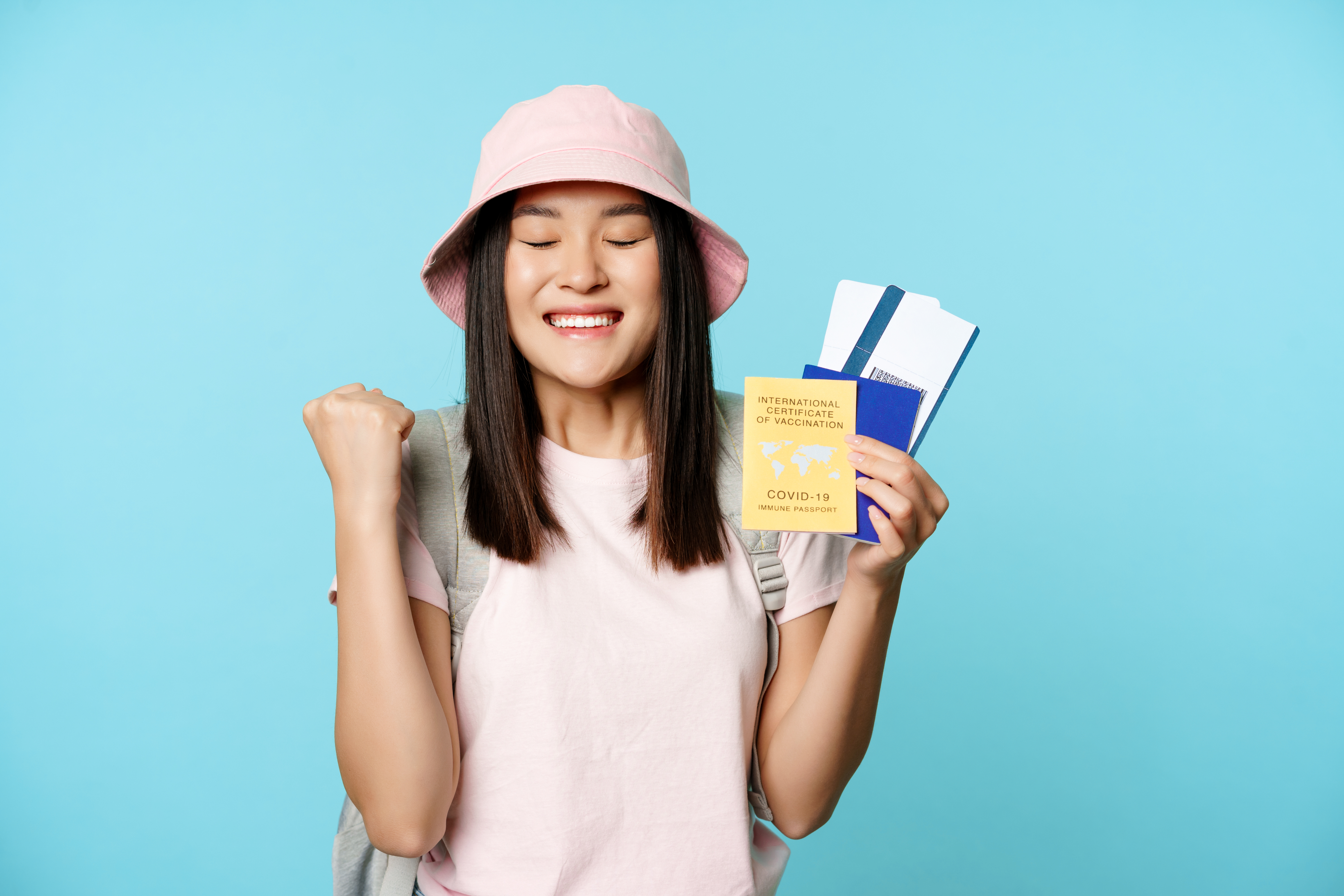 https://img.moneyduck.com/article_attachment/1663644921-happy-asian-girl-triumphing-showing-vaccination-certificate-health-passport-flight-tickets-celeb.jpg
