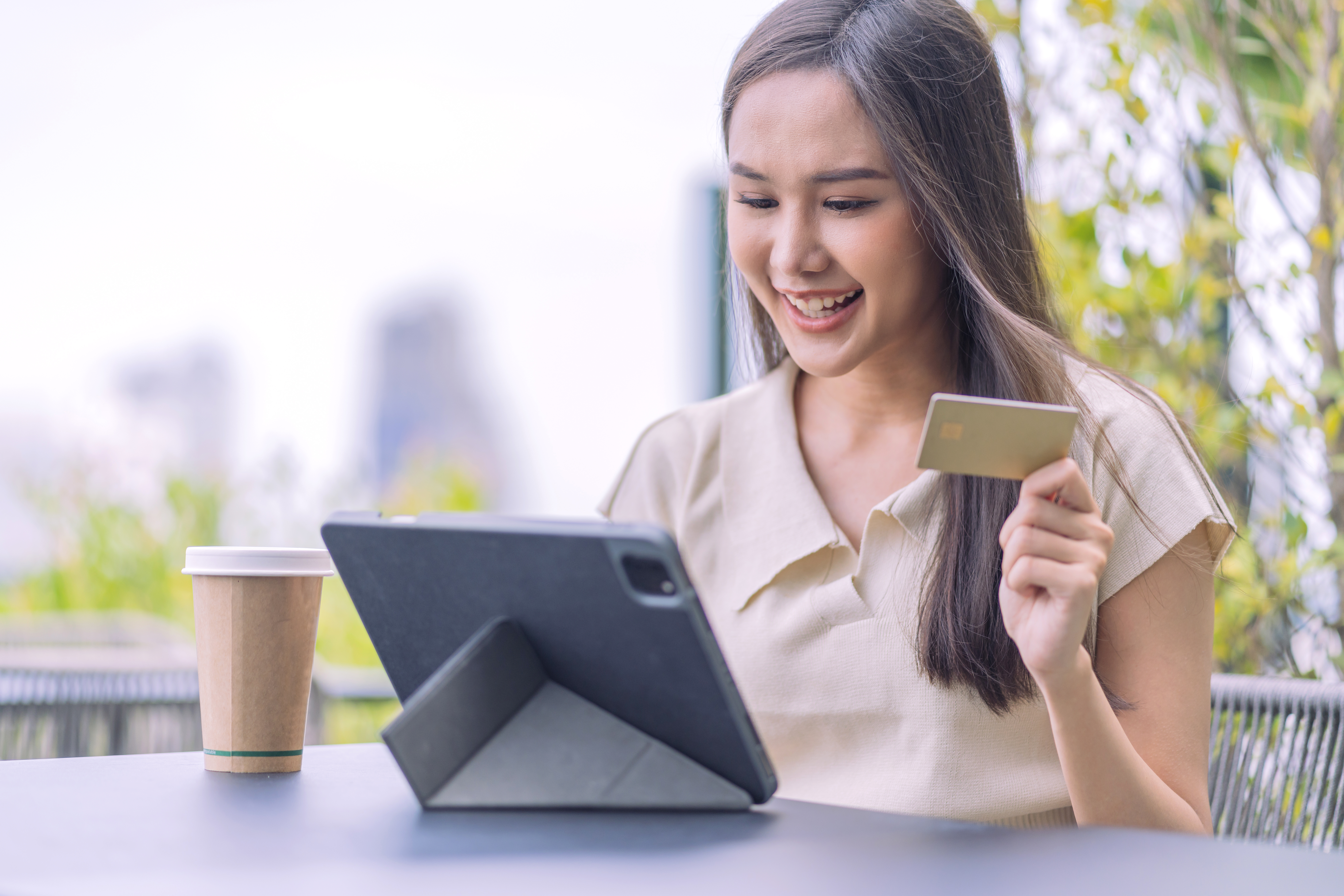 https://img.moneyduck.com/article_attachment/1664257528-asian-woman-is-buying-online-paying-with-credit-cardfemale-sitting-cafe-outdoor-enjoying-weekend-vacation-shopping-online-smartphone-making-mobile-payment-with-credit-card.jpg