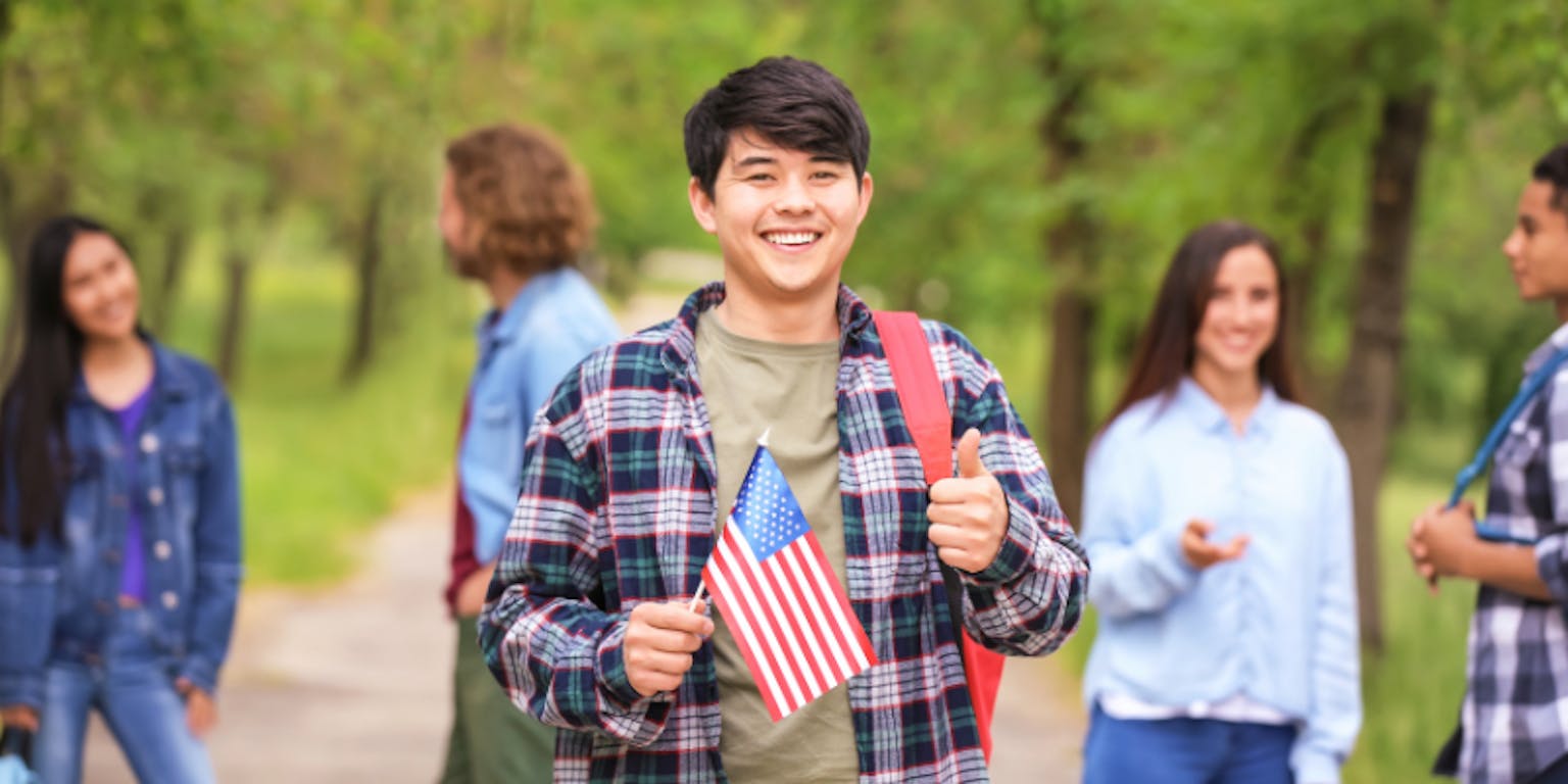 Seorang pria Asia memegang bendera Amerika