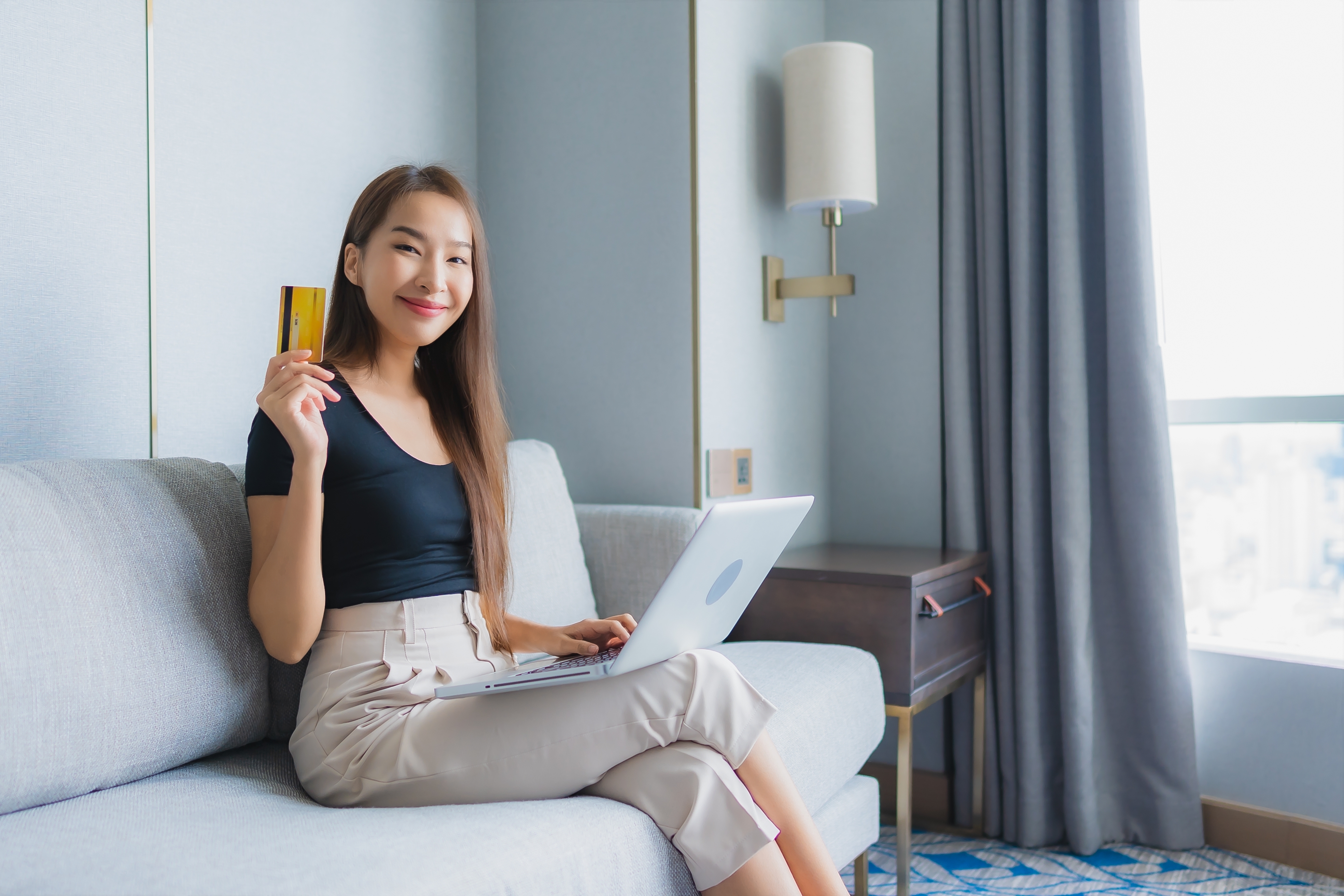 https://img.moneyduck.com/article_attachment/1688460491-portrait-beautiful-young-asian-woman-use-smart-mobile-phone-laptop-with-credit-card-sofa-living-room-area.jpg