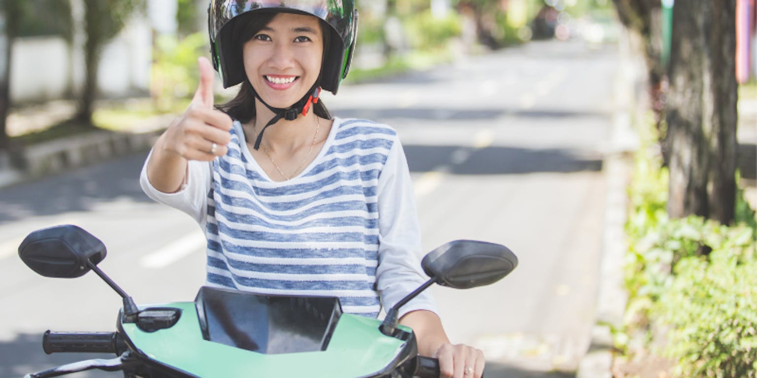 Ilustrasi seorang wanita mengendarai motor.