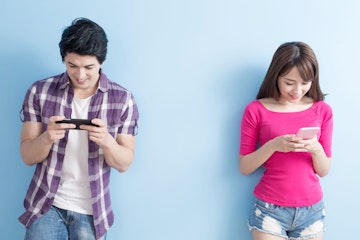 Stock Photo - young couple use phone happily with blue background